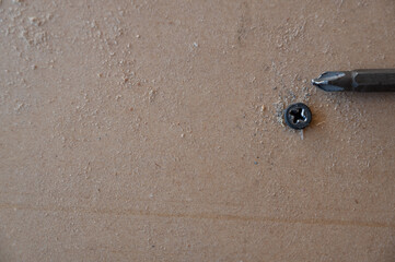 Stripped and damaged Philips screw on a wood surface