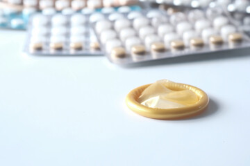close up of condom and birth control pill on white 