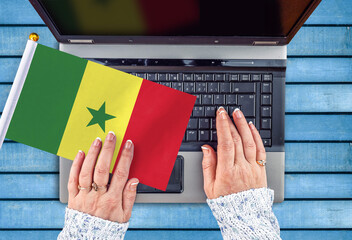 woman hands and flag of Senegal on computer, laptop keyboard 