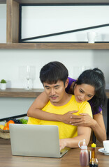 Happy and funny family. Asian lovely couple, beautiful woman and handsome man is having breakfast, talking in the kitchen