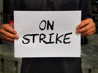 Selective focus on man holding board with text on strike.Business concept.