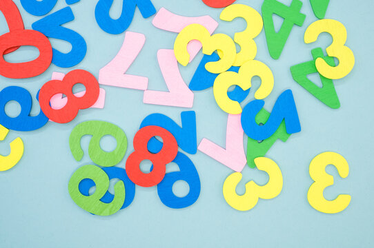 A top view of the colorful wooden numbers scattered on a blue surface
