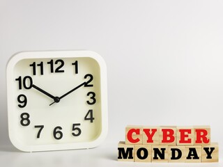 Text CYBER MONDAY on wooden cubes with alarm clock isolated on white background.Business concept.