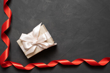 red satin ribbon on a concrete background. box with a bow. The concept of a gift for loved ones on February 14. Baner.