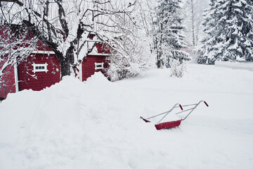 red snow shovel in snow