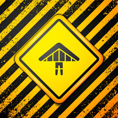 Black Hang glider icon isolated on yellow background. Extreme sport. Warning sign. Vector Illustration.