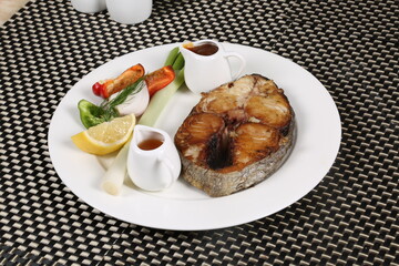 Deep oil fried fish slice served with vegetable and sauces  slices lemon