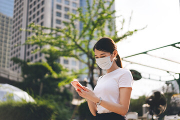 Young adult business asian working woman wear face mask for protect virus corona or covid19 using mobile phone application