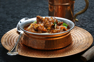 Pakistani famous North Indian curry lamb gosht mutton nirahi karahi kadai bronze bowl black...