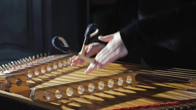 Musician playing the hammered dulcimer close-up. Female hands play the stringed instrument dulcimer.