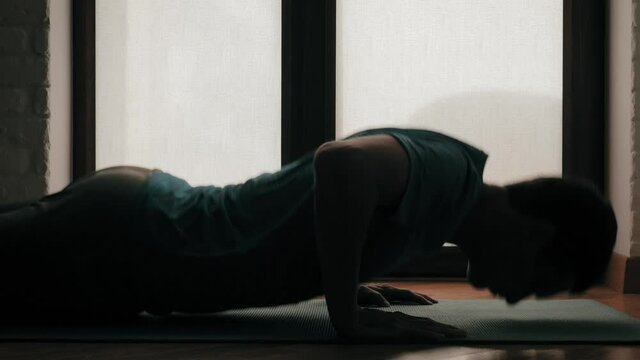 strong young man doing push ups at home during quarantine self isolation