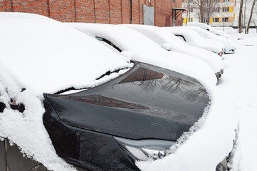 Cars covered with a thick layer of snow
