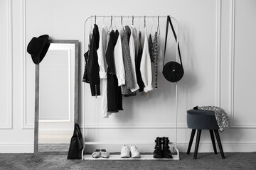 Rack with stylish clothes in modern dressing room