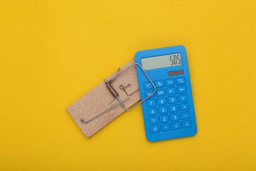 Mousetrap with calculator on a yellow background. Business concept