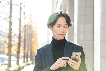 スマートフォンを操作する男性 冬 都会