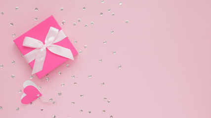 Obraz na płótnie Canvas Pink gift box and confetti on pink background, Happy Valentine's Day concept