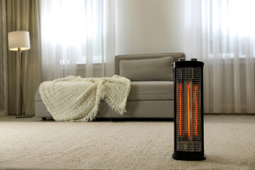 Modern electric halogen heater on floor in living room interior © New Africa