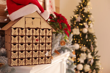 Wooden house shaped Advent calendar in room decorated for New Year