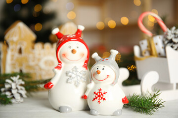 Christmas composition with decorative snowmen on white wooden table