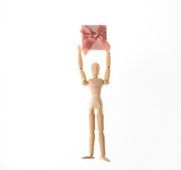 Wooden puppet holding gift box isolated on white background