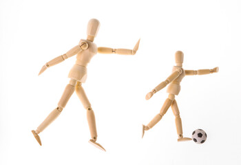 Wooden puppets dummy playing soccer isolated on white background