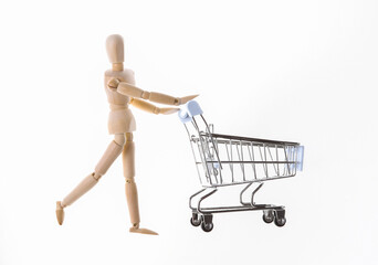 Shopping concept. Wooden puppet with supermarket trolley isolated on white background