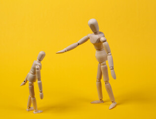 Angry parent puppet points with hand and scolds the child. Negative emotion, teenage problem concept. Isolated on yellow