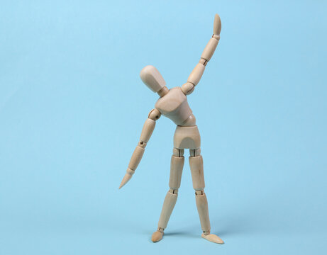 Wooden puppet practicing aerobics on blue background - Powered by Adobe