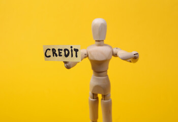 Text credit with wooden puppet figure on yellow background
