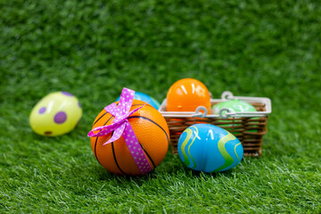Basketball with Easter Eggs on green grass for Easter Holiday
