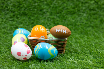 American football with Easter eggs on green grass