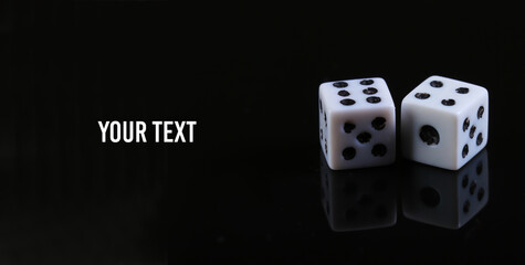 Two dice on a black background with reflection. Copy space