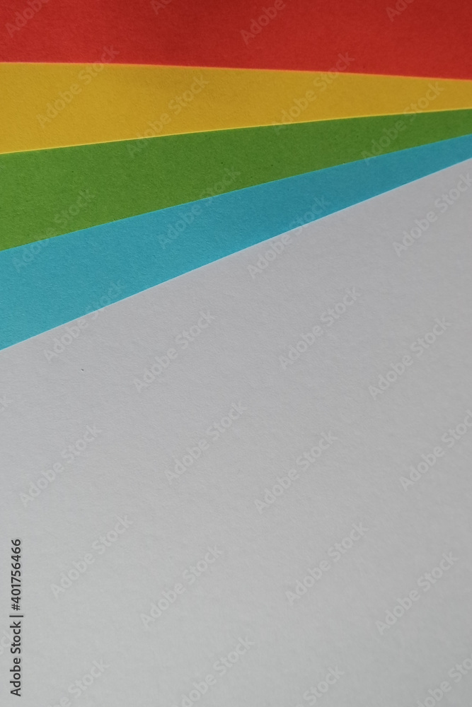 Poster a vertical shot of colored papers on the top of a gray surface with a copy space
