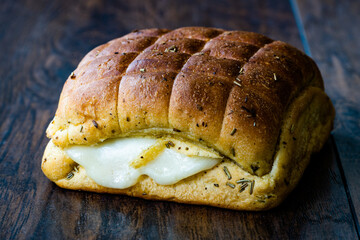 Freshly Baked Homemade Ligurian Focaccia Bread Half Cut with Melted Mozzarella Cheese, Olive and Tomatoes on Dark Wooden Surface.