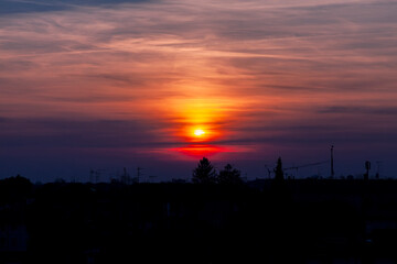Tramonto sulla città storica fortezza di Palmanova con sagome delle case, edifici, antenne, ponteggi e bandiera.