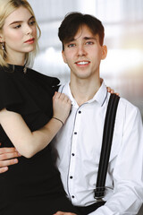 Young couple of businessman and woman are standing in a modern office. Portrait of successful business people