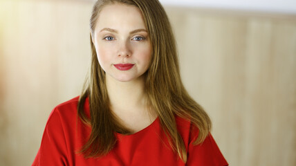 Fototapeta premium Head shot of a smart confident smiling millennial european woman standing with folded arms at home