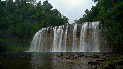 Tinuy-an Falls waterfalls in a mountain gorge in the tropical jungle, Philippines, Mindanao. Waterfall in the tropical forest.