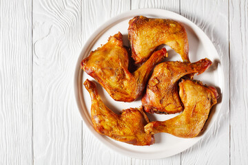 roast chicken legs on a white platter, top view