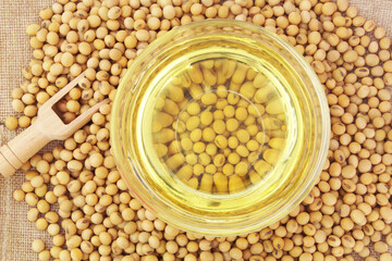 Soy beans oil and soy beans with wooden scoop, top view