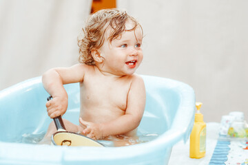 a little boy is bathing in a bath