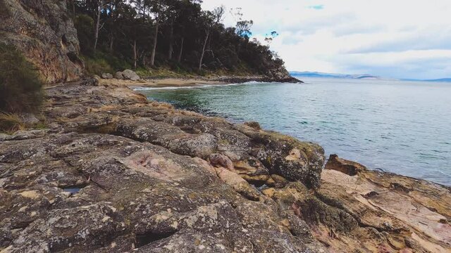pristine wild landscape at Boronia Beach in Tasmania, Australia with lush vegetation and rocks on the shore