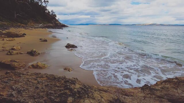 pristine wild landscape at Boronia Beach in Tasmania, Australia with lush vegetation and rocks on the shore