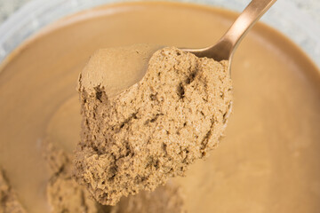 bronze colored spoon with brown chocolate mousse