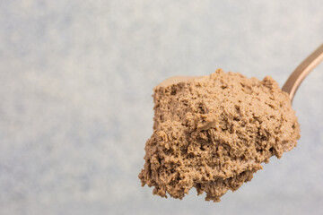 bronze colored spoon with brown chocolate mousse