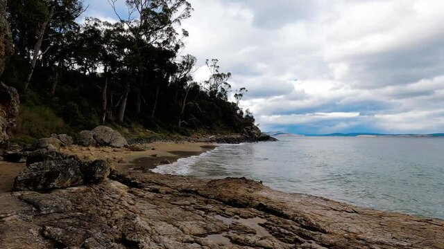 pristine wild landscape at Boronia Beach in Tasmania, Australia with lush vegetation and rocks on the shore