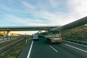 Special transport of blades for wind turbines, truck transporting a wind turbine blade that, due to its large size, requires a special adapted semi-trailer circulating on the highway and crossing unde