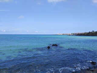 Fototapeta premium Jeju Island, beach, sea, cloud, black stone, rock, blue sky, Sunshine, tree, peace, horizon, emerald color, Korea
