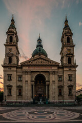 Fototapeta na wymiar St. Stephen's Basilica in Budapest Hungary. Beautiful sunrise at the church or cathedral in the middle of the city. Nice view through the street or square. backlit and old historical building
