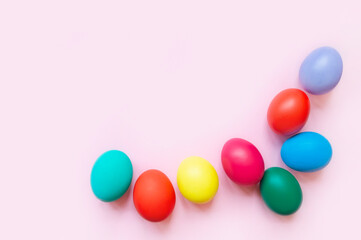 colorful easter eggs on pink background with copy space. Easter background